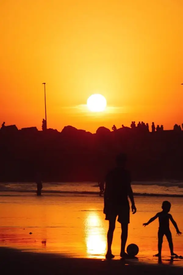 Familie som nyter en solnedgang på stranden