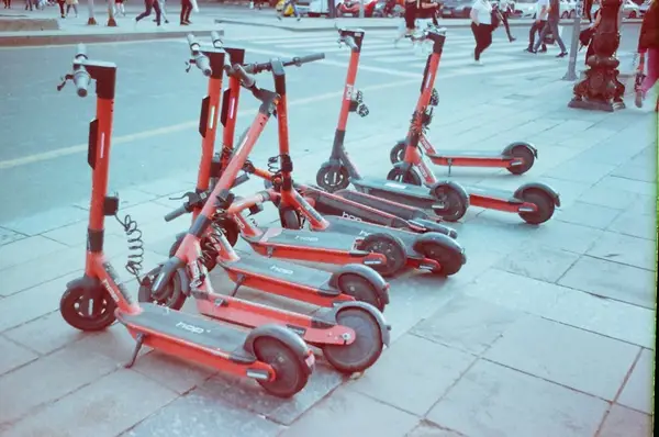 Moderne elektriske sparkesykler parkert i en by.